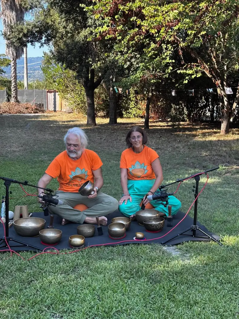 I facilitatori dell'Associazione Dharmonia seduti dietro al set di campane tibetane, all'aperto, prima di un bagno sonoro
